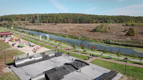 Skateboarders in outdoor skatepark. Professional skateboarders skateboarding in park alt