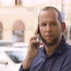 A Caucasian Man Talks on a Smartphone in an Urban Area  Closeup  a Colorful Street - VideoHive Item for Sale