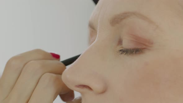 hands of makeup artist apply eyeshadow with brushes
