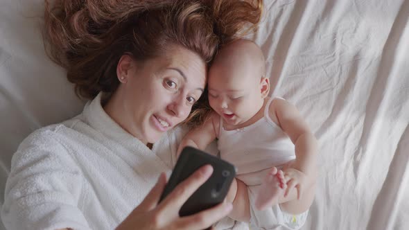 Close Up of Mother and Her Newborn Baby Making a Selfie or Video