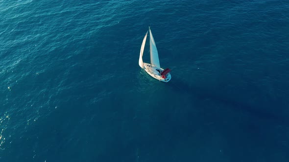 Aerial View. Yacht Sailing on Opened Sea. Yachting with Sails Up at Windy Day. alt