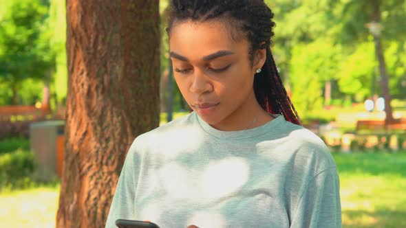 Close Up Girl Chat Online or Text Message on Mobile Outdoors