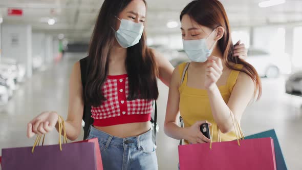 Asian woman wearing face mask. Happy woman with shopping bags enjoying in shopping