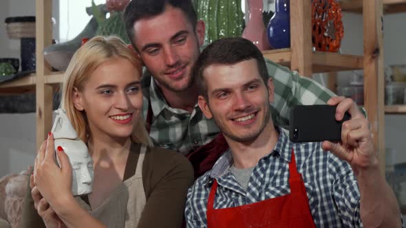 Group of Young Professional Sculptors Taking Selfies After Working alt