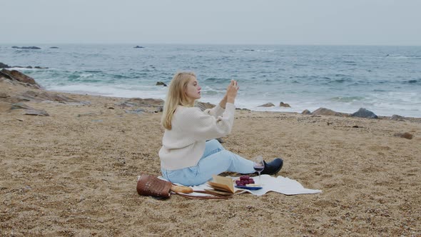 Woman Takes Photo of Beautiful Ocean