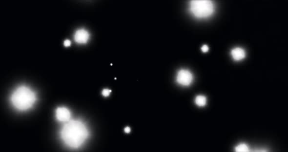 Animation of glowing white spots of light moving in hypnotic motion on black background alt