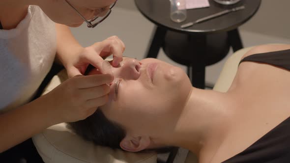 Beautician Professional Hands Distributing Eye Lashes of the Client on the Silicone Pad for