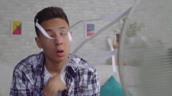 Saddened Young Asian Man Saved From the Heat Sitting in Front of a Working Fan Slow Mo alt