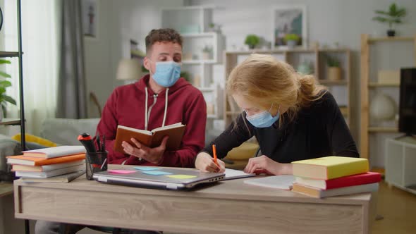 Young Tutor Man is Studying with a Young Woman at Her Home During Quarantine alt
