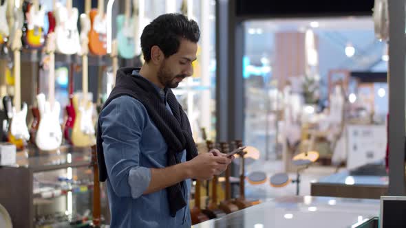 Young handsome man using smartphone and payment by smartphone contactless