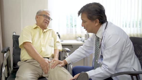 Orthopedist examines the knee of elderly patient to collect information for physical therapy treated alt