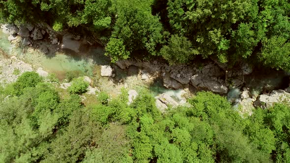 Aerial view of a person going across the Soca River on a zip line in Slovenia. alt