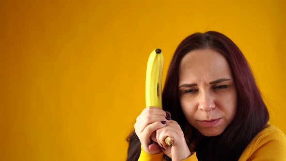 Portrait of Young Woman with Banana on Yellow Background alt