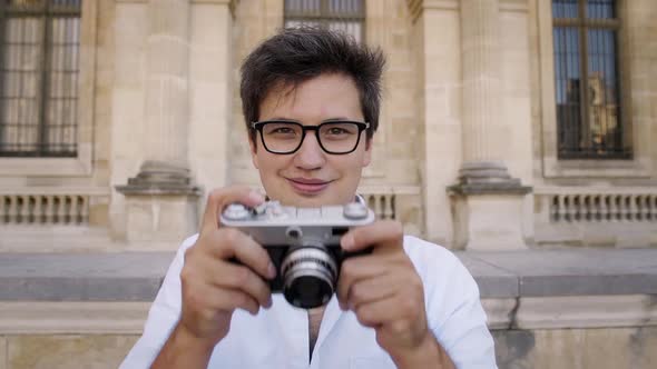 Handsome Man in White Shirt Taking a Picture of Architecture in Paris