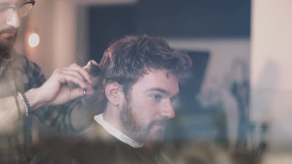 Young Adult Male having haircut in barbershop