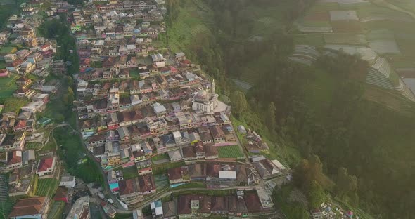 Aerial top down shot of colorful houses and apartments located on dangerous hill of Mount Sumbing - alt