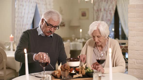 Husband and Wife Enjoying Fondue in Hotel Restaurant alt