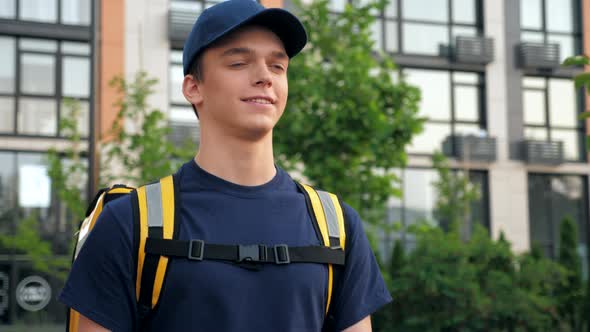 Close Up Smiling Delivery Man Courier with Thermal Backpack to Deliver Order alt