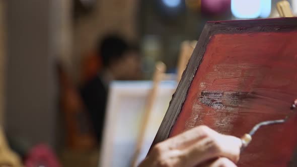 Closeup of Man's Hand Painting Using Oil Paints and Palette Knife at School or at Master Class alt