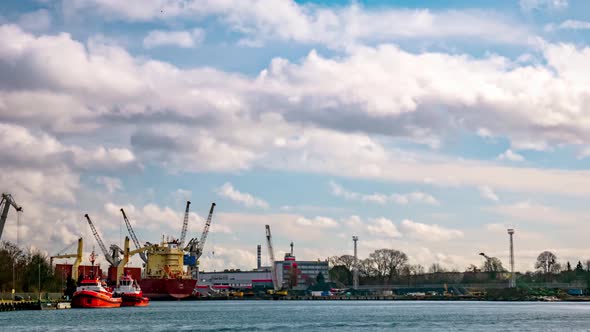 Industrial Harbour Timelapse. Moving Clouds and Blue Sky. Ships Passing By. Bay of Gdansk, Poland. 