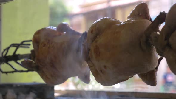 Close-up Shot of Cooking Appetizing Chicken on a Spit with a Light, Fragrant Smoke alt