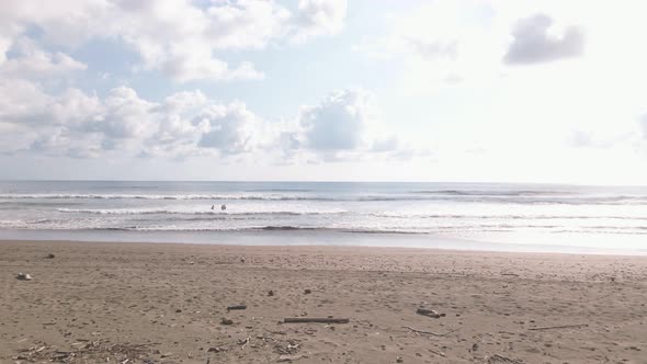 Aerial View of three people in the Dominical Beach In Costa Rica, Tracking Shot Wide. alt