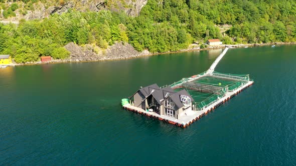 Cinematic Aerial view of a fish farm in Fjord of Norway alt