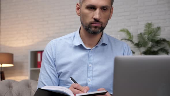 Close Up Man Trader Broker Listens Investor Online Laptop Notes in Notebook alt