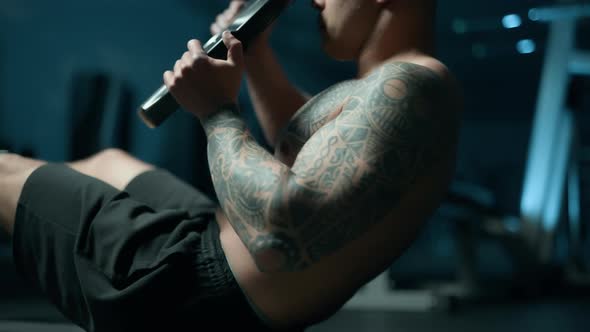 A Handsome Young Muscular Sportsman is Doing Exercise on a Fitness Machine in the Gym alt