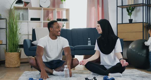 Couple which Sitting in Lotus Pose at Home and Talking with Giving High Five alt