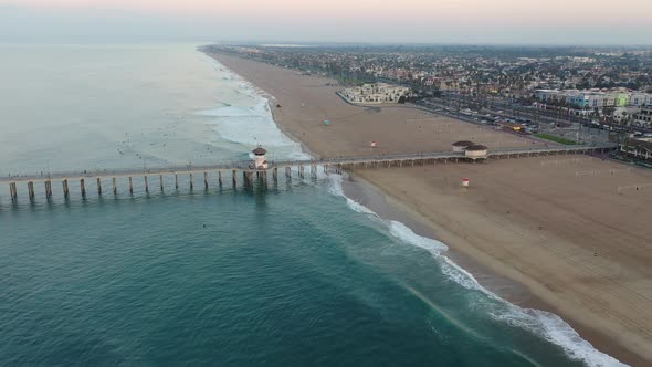4k ariel drone shot heading straight down the pier in California, Surf City USA as a military troop alt