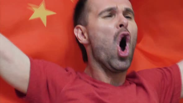 Chinese Fan Celebrating While Holding the Chinese Flag alt