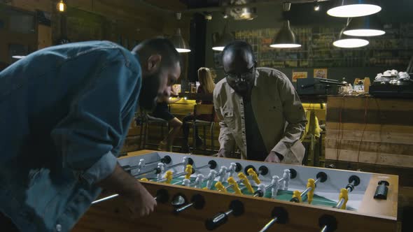 Friends playing table soccer