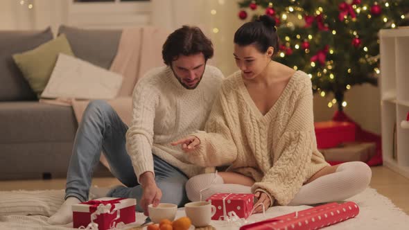 Christmas and New Year Gift Wrapping By Couple at Home During Winter Holidays alt