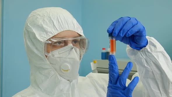 Laboratory a Female Virologist Examines a Test Tube Containing a Virus Vaccine for