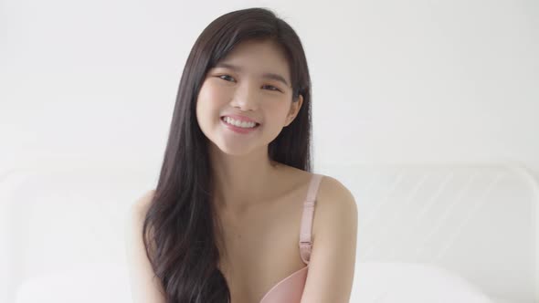 Beautiful young asian woman sexy in underwear smiling and laughing with happy at room. alt