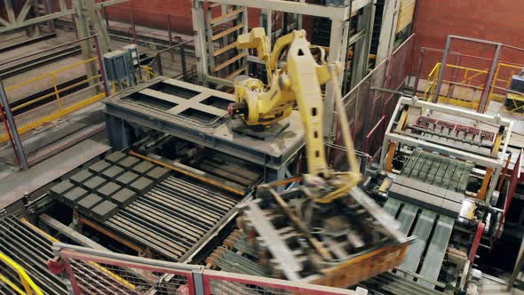 Modern Industrial Robotic Arm Moves Bricks at a Factory alt
