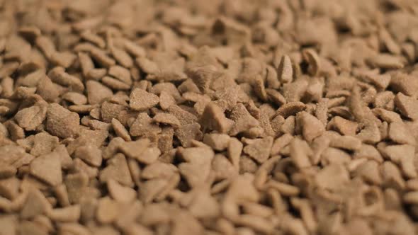 Slow motion shot Petfood Triangle Shape grains slowly falling on Pile - static alt