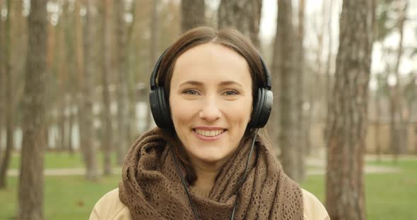 Portrait of woman put on headphones and listening to music. Girl enjoying music in earphones alt