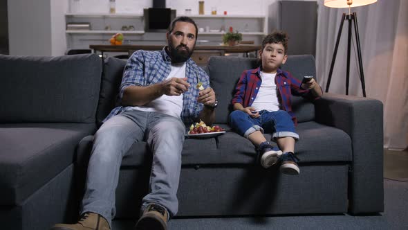 Relaxed Father and Son Watching Movie on Tv alt