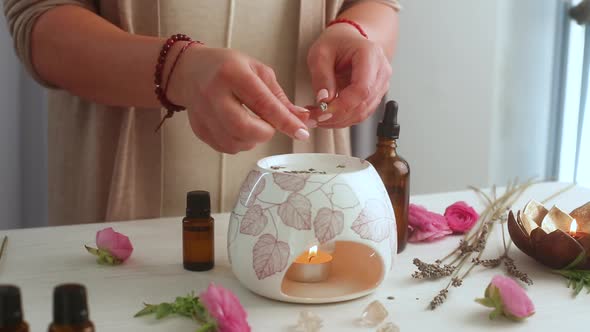 Woman takes care of her skin at home, prepares an aroma lamp and oils