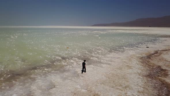 Single Man Walking Lonely on White Urmia Salt Lake, Iran