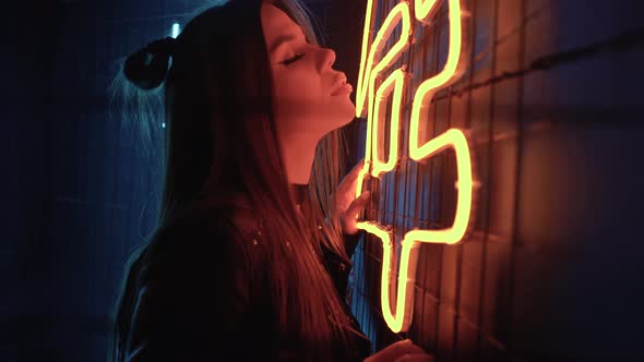 Young Beautiful Confident Caucasian Girl Posing at a Party Near Neon Lamps alt