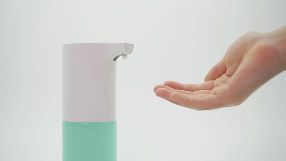 Close-up of Hands and Automatic Dispenser, Disinfector on an Isolated Background, Close-up alt