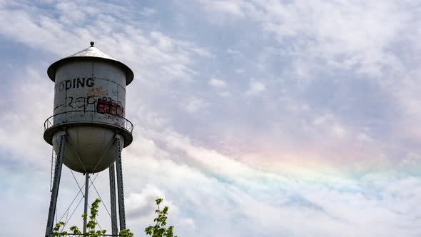 Colorful time lapse of a fire rainbow behind water tower alt