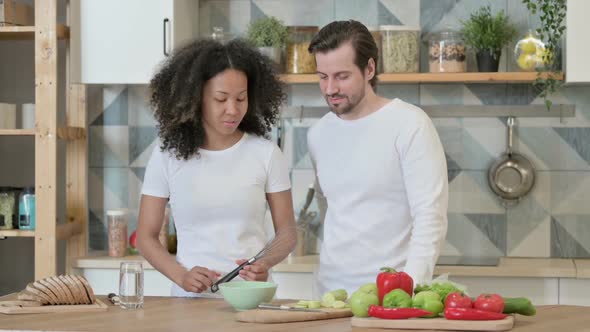 Mixed Race Couple Talking While Standing in Kitchen alt