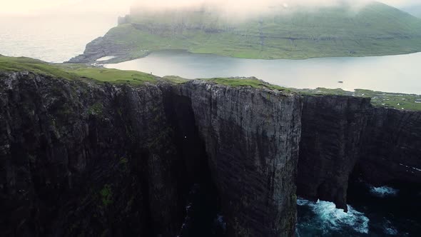 Aerial view of tourists English Slave cliff on North Atlantic sea, Faroe island. alt