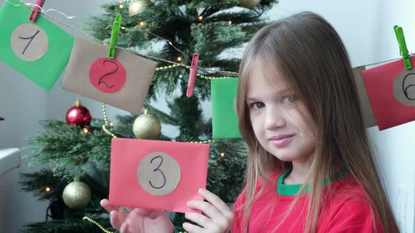 Advent Christmas Calendar Portrait of a Smiling Little Girl Taking Envelope Numbered 3 Selective alt
