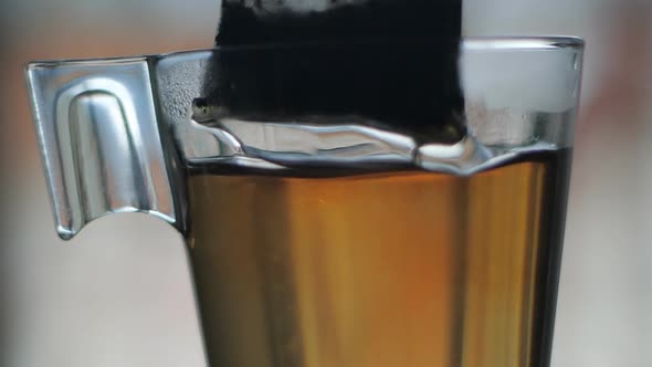 Tea bag in glass cup slow motion