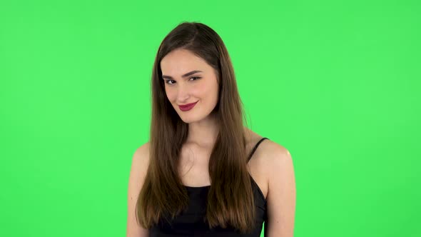Lovely Girl Smiles Broadly and Winks Flirting. Green Screen alt